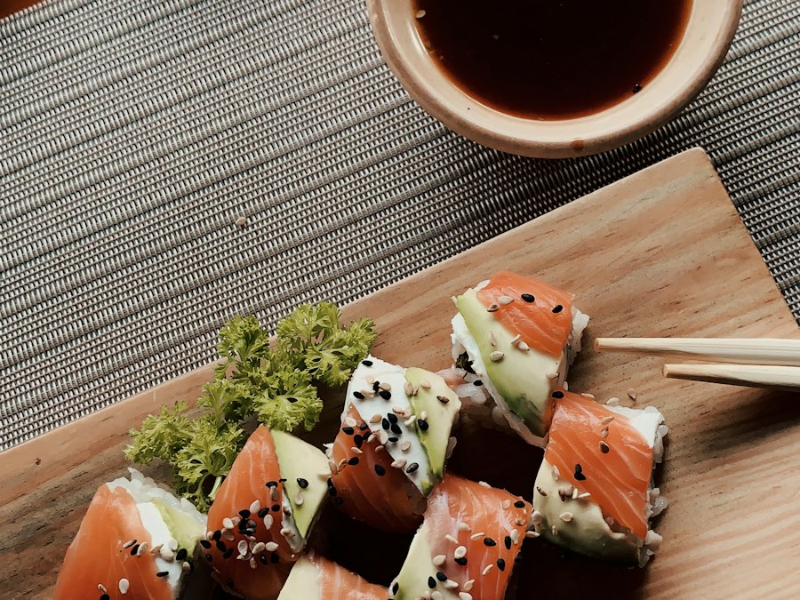 Salmon and avocado sushi rolls on a wooden board with soy sauce